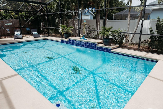 view of pool with a lanai, pool water feature, and a patio