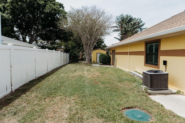 view of yard featuring a storage shed and central AC unit