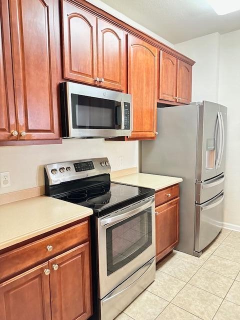 kitchen with appliances with stainless steel finishes and light tile floors