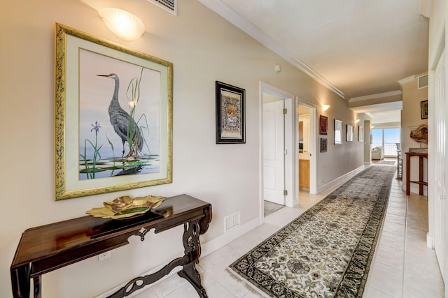 hall with crown molding and light tile patterned floors