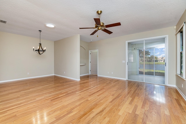 unfurnished room featuring ceiling fan with notable chandelier, a textured ceiling, and light wood-type flooring