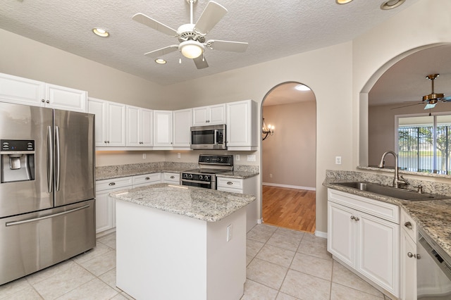 kitchen featuring sink, ceiling fan, light tile flooring, and stainless steel appliances