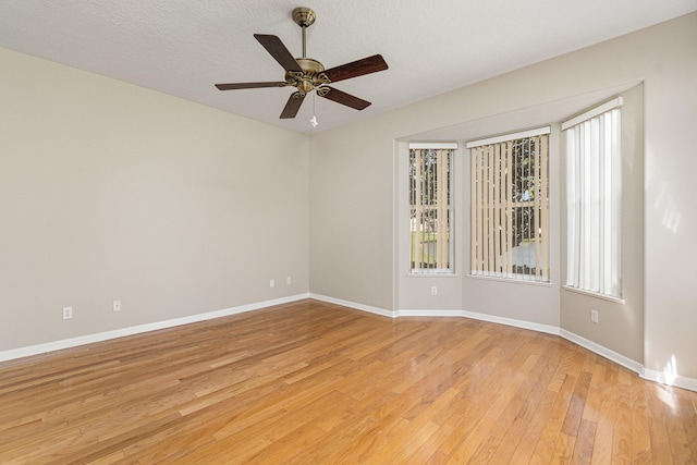 spare room with a textured ceiling, ceiling fan, and light wood-type flooring