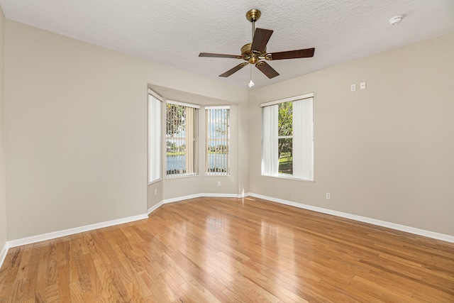 empty room with light hardwood / wood-style flooring, ceiling fan, and a textured ceiling