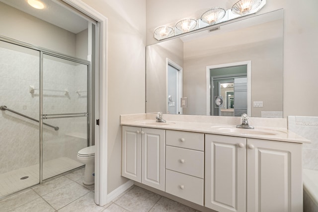 bathroom featuring tile flooring, double sink vanity, toilet, and walk in shower