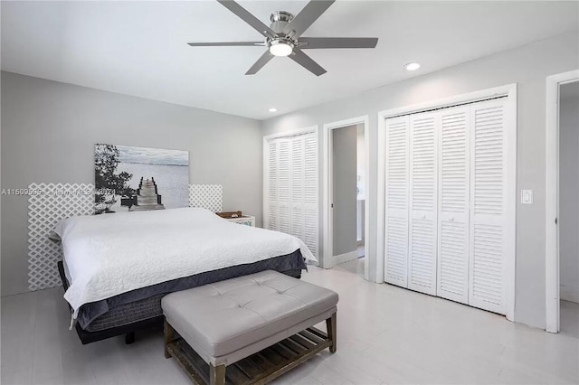 bedroom featuring ceiling fan, light hardwood / wood-style flooring, and two closets