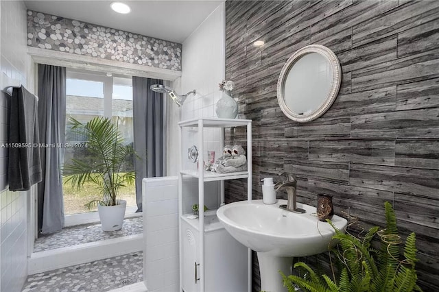 bathroom with a healthy amount of sunlight, tile floors, and tile walls