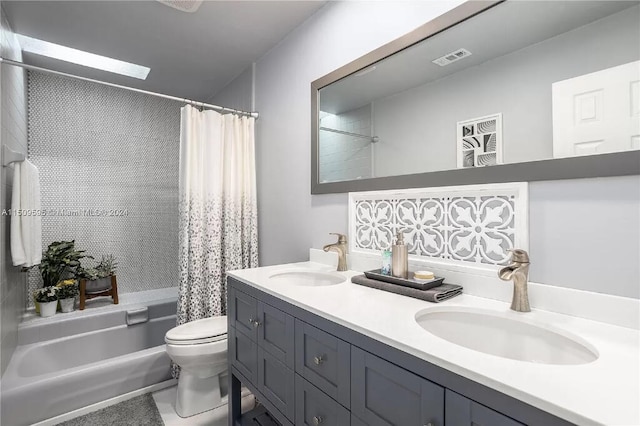 full bathroom featuring dual vanity, toilet, and shower / tub combo with curtain