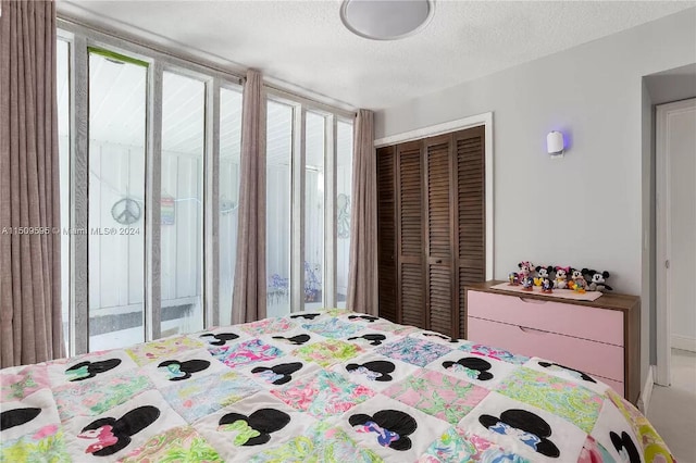 bedroom featuring a closet, a textured ceiling, and multiple windows