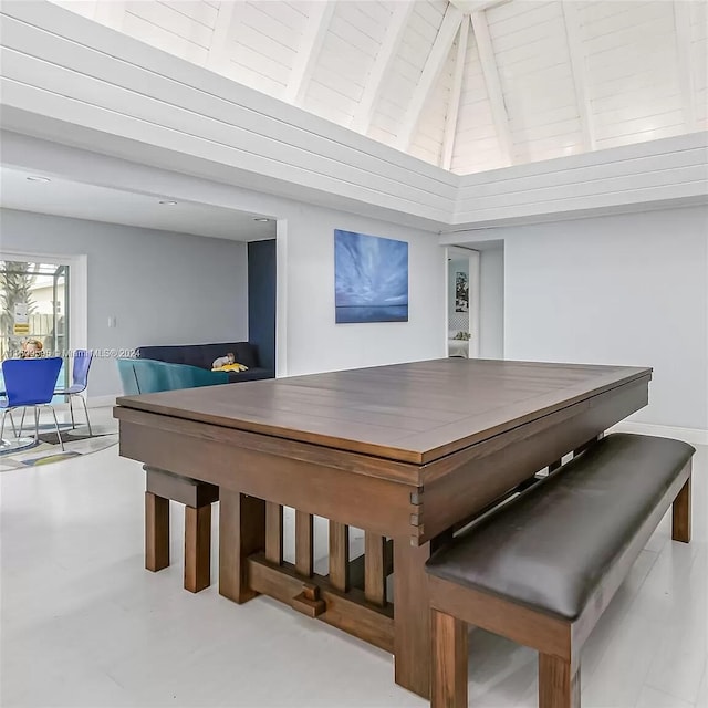 dining space featuring vaulted ceiling with beams