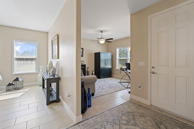 tiled entrance foyer with ceiling fan