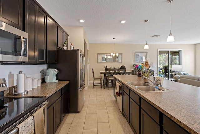 kitchen with decorative light fixtures, light tile patterned floors, sink, and appliances with stainless steel finishes