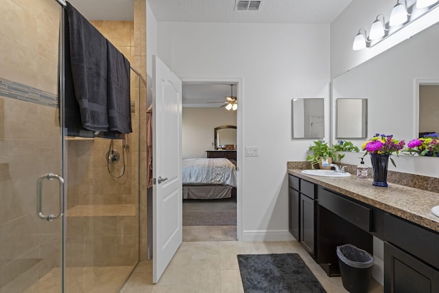 bathroom with tile patterned floors, ceiling fan, a shower with door, and vanity