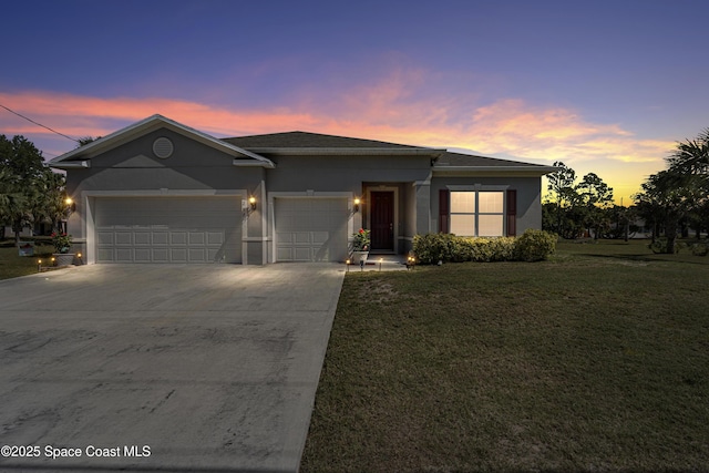 view of front of property featuring a garage and a yard