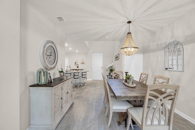 dining space with an inviting chandelier and light wood-type flooring