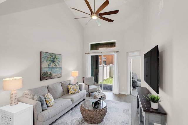 living room featuring light hardwood / wood-style flooring, ceiling fan, and high vaulted ceiling