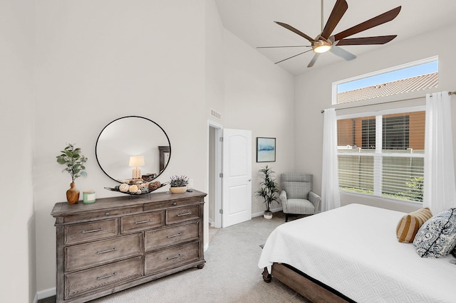 bedroom featuring high vaulted ceiling, light colored carpet, ceiling fan, and multiple windows