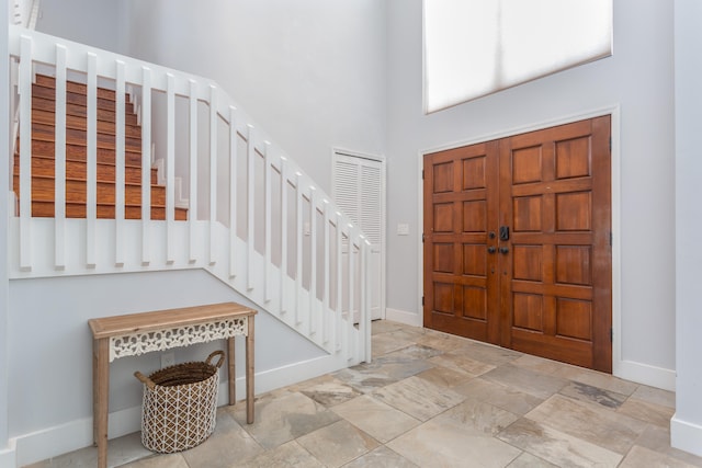 foyer entrance with a towering ceiling and light tile flooring