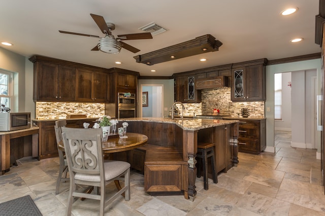 kitchen featuring premium range hood, tasteful backsplash, ceiling fan, and appliances with stainless steel finishes