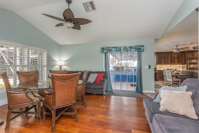 dining room featuring hardwood / wood-style flooring, a wealth of natural light, ceiling fan, and lofted ceiling