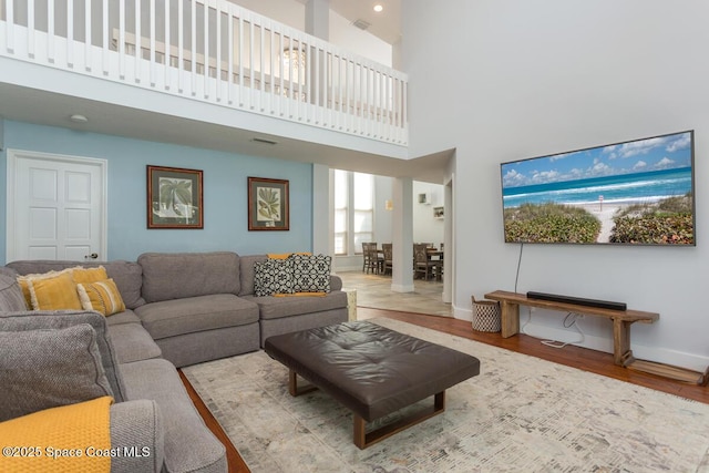 living area featuring light wood-type flooring, visible vents, and baseboards