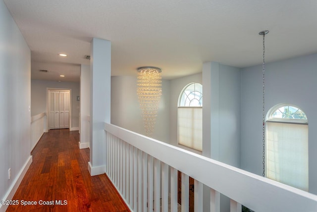 hall featuring dark wood-style floors, recessed lighting, visible vents, and baseboards