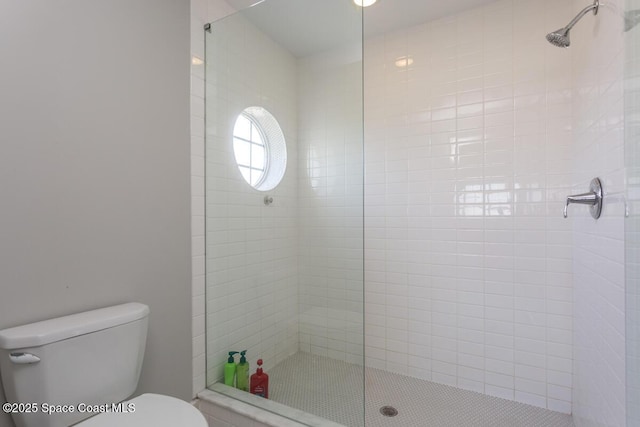 bathroom featuring toilet and a shower stall