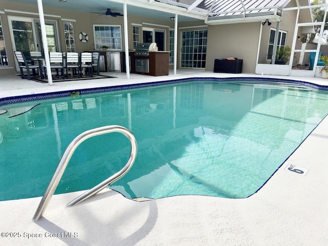 pool featuring a patio, an outdoor kitchen, a ceiling fan, a grill, and a lanai