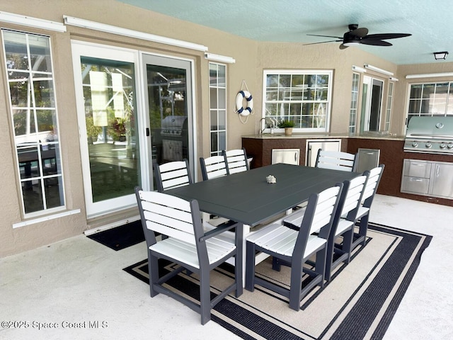 view of patio / terrace with outdoor dining area, an outdoor kitchen, a grill, and a ceiling fan