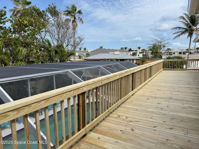 deck featuring a lanai, a residential view, and an outdoor pool