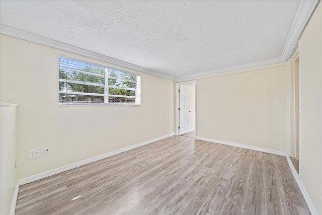 spare room featuring ornamental molding, light hardwood / wood-style floors, and a textured ceiling