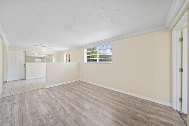 tiled empty room featuring ornamental molding, ceiling fan, and a textured ceiling