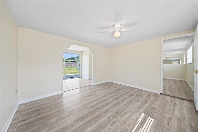 empty room with ceiling fan and light hardwood / wood-style floors