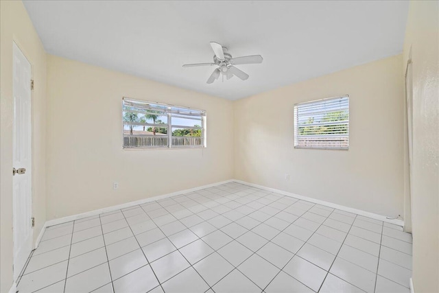 spare room with plenty of natural light, ceiling fan, and light tile flooring