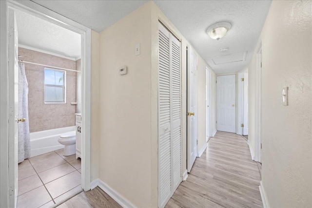 corridor featuring light tile floors and a textured ceiling