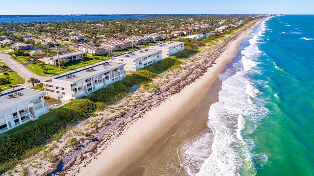 birds eye view of property featuring a beach view and a water view