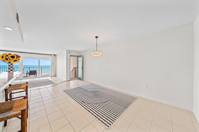 interior space with a water view, light tile flooring, and a chandelier