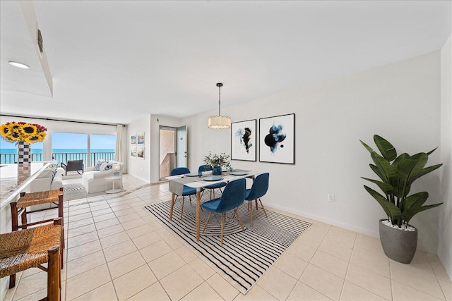 dining space featuring light tile floors and a water view