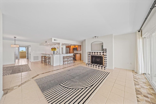 unfurnished living room with light tile flooring and a tile fireplace