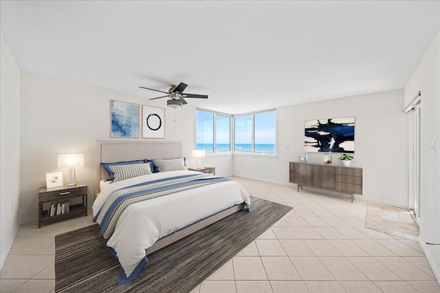 bedroom featuring a water view, ceiling fan, and light tile floors