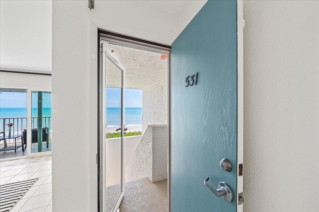 interior space with a water view and light tile floors