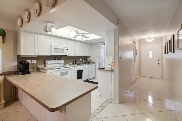 kitchen with white cabinets, white appliances, light tile flooring, kitchen peninsula, and ceiling fan