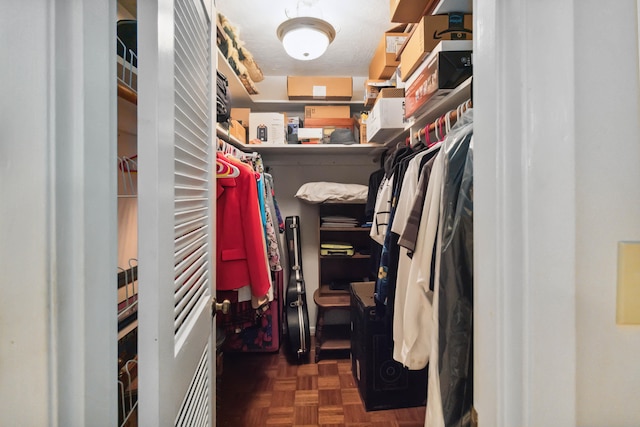 spacious closet featuring dark parquet flooring