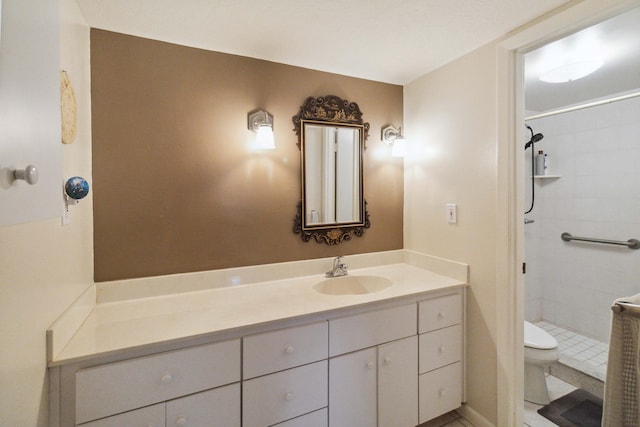 bathroom with tiled shower, tile flooring, vanity, and toilet