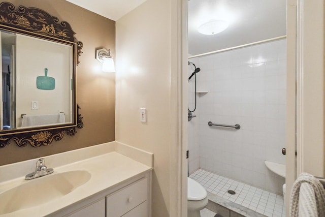 bathroom featuring vanity, toilet, and a tile shower