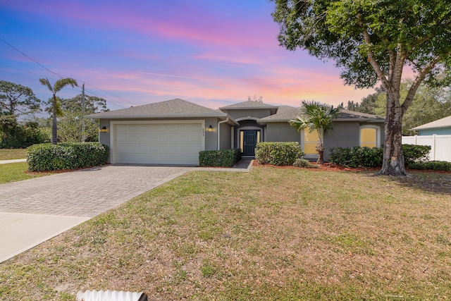 view of front of house with a garage and a lawn