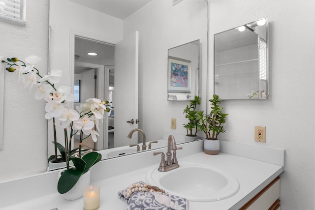 bathroom featuring walk in shower and vanity