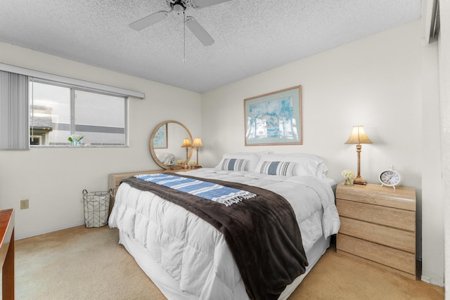 bedroom with light carpet, ceiling fan, and a textured ceiling