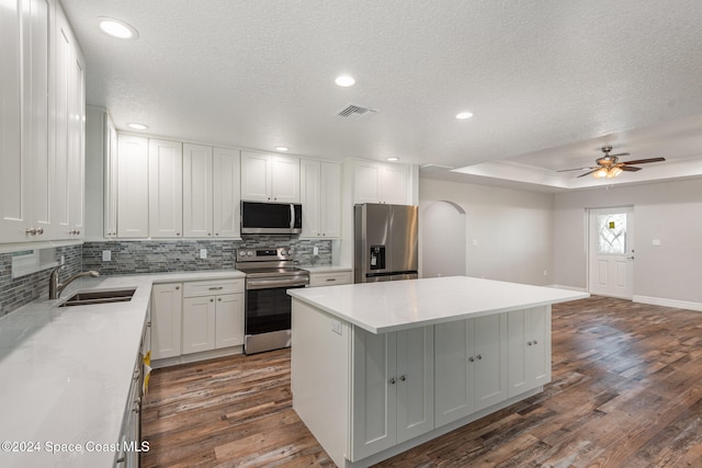 kitchen with a center island, dark hardwood / wood-style flooring, white cabinetry, and stainless steel appliances