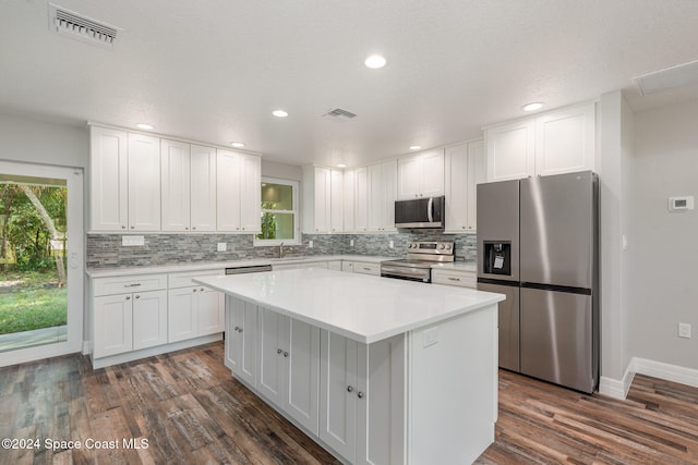 kitchen featuring white cabinetry, stainless steel appliances, a wealth of natural light, and dark wood-type flooring